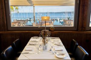 einen Tisch in einem Restaurant mit Blick auf ein Boot in der Unterkunft Marina Hotel am Starnberger See in Bernried