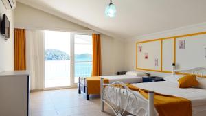 a bedroom with two beds and a large window at Yazıcı Otel Bozburun in Marmaris