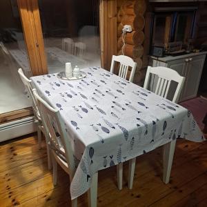 una mesa y sillas con un mantel blanco en Helmi Äärelä, en Vuotso