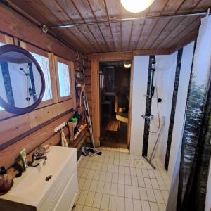 a bathroom with a sink and a shower with a mirror at Helmi Äärelä in Vuotso