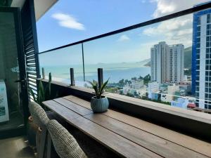 a wooden table with a potted plant on a balcony at Wins House - FLC Sea Tower Quy Nhơn in Quy Nhon