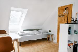 a small bedroom with a bed and a table at Vila Ana - 2 room apartment in Vejle