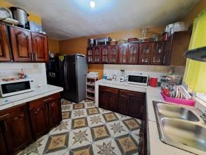 een keuken met houten kasten en een zwarte koelkast bij 237 Bratton Avenue in Montego Bay