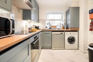 a kitchen with a sink and a washing machine at Spacious 4-bedroom townhouse in the city center with free parking in Oxford