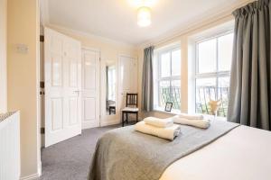 a bedroom with a large bed with two pillows on it at Spacious 4-bedroom townhouse in the city center with free parking in Oxford