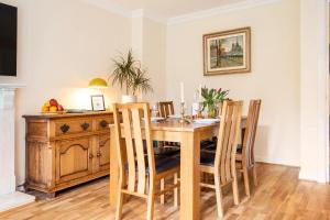 a dining room with a wooden table and chairs at Spacious 4-bedroom townhouse in the city center with free parking in Oxford