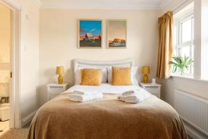 um quarto com uma cama com duas toalhas em Spacious 4-bedroom townhouse in the city center with free parking em Oxford