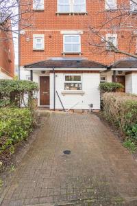 a house with a brick driveway in front of a building at Spacious 4-bedroom townhouse in the city center with free parking in Oxford