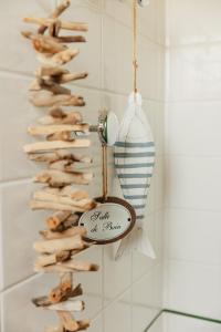 a driftwood christmas tree with a sign on a wall at LE CLOS POULAIN Petits gîtes de charme et chambres d'hôtes Familiales au calme proche Bayeux et des plages in Nonant