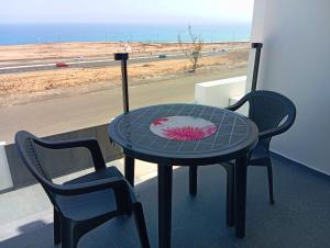 a table and two chairs on a balcony with a view of the beach at Vista Playa Blanca in Puerto del Rosario