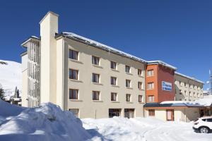 een gebouw met een berg sneeuw ervoor bij Hôtel Club mmv Le Panorama *** in Les Deux Alpes