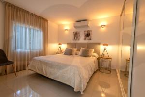 ein Schlafzimmer mit einem Bett mit zwei Lampen und einem Fenster in der Unterkunft VILLA SIEMPRE DOMINGO MARBELLA in Marbella + 38 Fotos