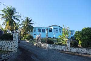 a street in front of a house with palm trees at Sunshine Lodge: Your home away from home in Montego Bay