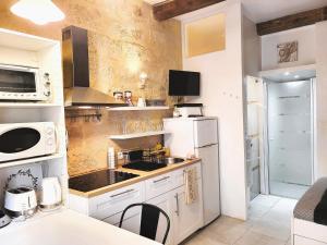 eine Küche mit einem weißen Kühlschrank und einer Spüle in der Unterkunft RAVISSANT STUDIO in Uzès