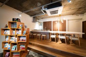 a kitchen with a table and chairs and a book shelf at MANGA ART HOTEL, BAKUROCHO in Tokyo