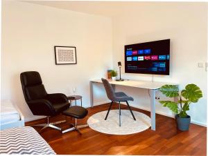 a room with a desk and two chairs and a tv at 2-Zi. Apartment 42 qm, an der Friedrichsau/Messe in Neu Ulm