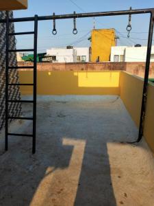 a gym with a yellow wall and a ladder at A Private Room With Terrace in Ahmedabad