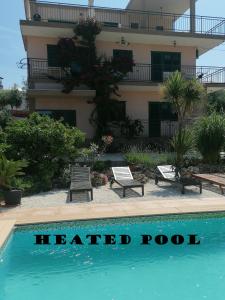um hotel com uma piscina aquecida em frente a um edifício em Villa Olma em Trogir