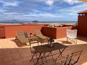 a patio with chairs and a table on a roof at Bella vista in Corralejo
