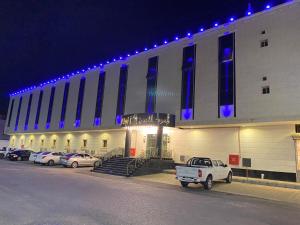 a building with cars parked in front of it at night at Zmroud Al-Morouj in Yanbu