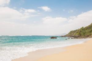 a sandy beach with the ocean in the background at 木の温かみ溢れる自然の中のログハウス～Cottage HIBISCUS～ in Inbu +38 photos