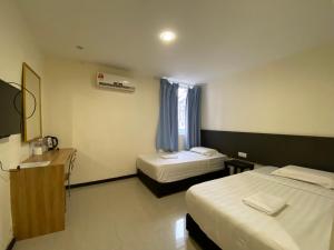 Cette chambre comprend 2 lits et une fenêtre. dans l'établissement HOTEL MALAYSIA, à Sibu