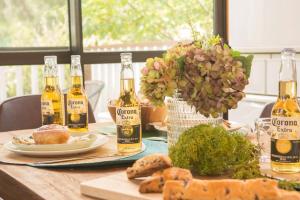 a table with bottles of wine and bread on it at 木の温かみ溢れる自然の中のログハウス～Cottage HIBISCUS～ in Inbu