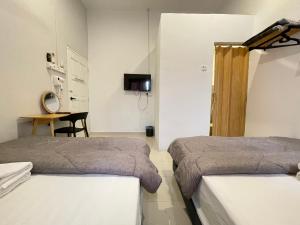 een hotelkamer met 2 bedden en een bureau bij Muslim Homestay Teluk Intan ( Hotel Style Room ) by Mr Homestay in Teluk Intan