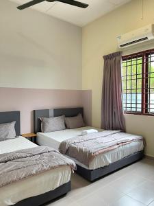 een slaapkamer met 2 bedden en een raam bij Muslim Homestay Teluk Intan ( Hotel Style Room ) by Mr Homestay in Teluk Intan