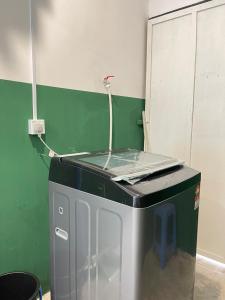 a washing machine in a room with a green wall at Muslim Homestay Teluk Intan ( Hotel Style Room ) by Mr Homestay in Teluk Intan