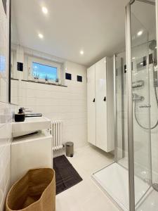 een witte badkamer met een douche en een wastafel bij Auszeit in idyllischer Lage in Bad Urach