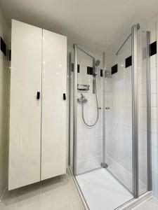 a shower stall in a bathroom with white tiles at Auszeit in idyllischer Lage in Bad Urach
