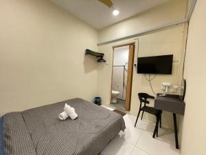 een slaapkamer met een bed met een knuffeldier erop bij Muslim Homestay Teluk Intan ( Hotel Style Room ) by Mr Homestay in Teluk Intan