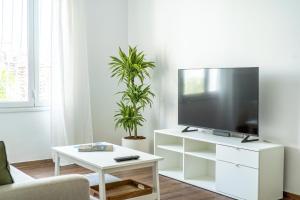 a living room with a tv on a white stand at Superb flat in the historic centre of Athens in Athens