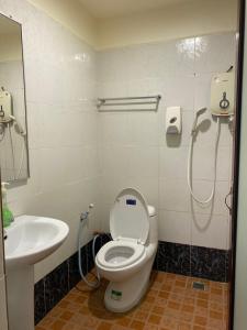 La salle de bains est pourvue de toilettes et d'un lavabo. dans l'établissement HOTEL MALAYSIA, à Sibu