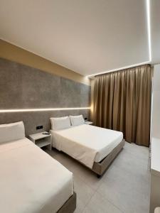 a hotel room with two beds and a window at Hotel Al Giardino in Treviso