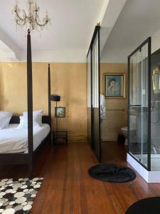 a bedroom with a bed and a bathroom with a chandelier at Demeure de 11 chambres avec piscine partagee et wifi a Pech Luna in Pech-Luna