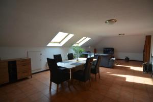 a dining room with a table and chairs and skylights at Ferienwohnung Späth in Ludwigswinkel