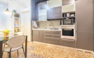 a kitchen with stainless steel appliances and a table at [A 2 passi da Piazza Grande] in Modena