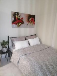 Στουντιο Βολος Ν Ιωνια في فولوس: غرفة نوم بسرير ودهان على الحائط