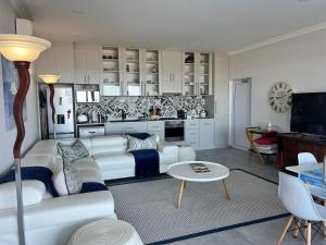 a living room with a white couch and a table at Shelley Point On Sea in St Helena Bay