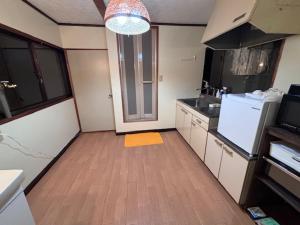 eine kleine Küche mit Holzboden und Kühlschrank in der Unterkunft Kumamoto Castle House in Kumamoto