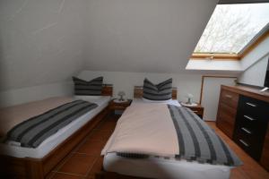 2 camas individuales en una habitación con ventana en Ferienwohnung Späth en Ludwigswinkel
