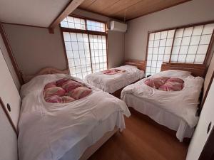 2 letti in una camera con 2 finestre di Kumamoto Castle House a Kumamoto