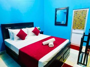 um quarto com uma cama grande e um cobertor vermelho em Hema Holiday Villa em Trincomalee