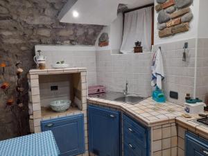 a small kitchen with blue cabinets and a sink at la taverna da Irene in Roe