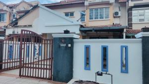 a white house with a gate and a building at Eing's Homestay - Muslim And Mahram Only in Kajang