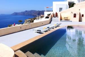 Villa Santorini 520 by Caldera Houses في أويا: مسبح مع كراسي وإطلالة على المحيط