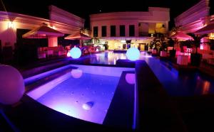 una piscina con luces moradas en un restaurante en The Penthouse Hotel and Residences, en Ángeles