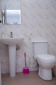 uma casa de banho com um WC branco e um lavatório. em Bellevue Apartment em Lagos